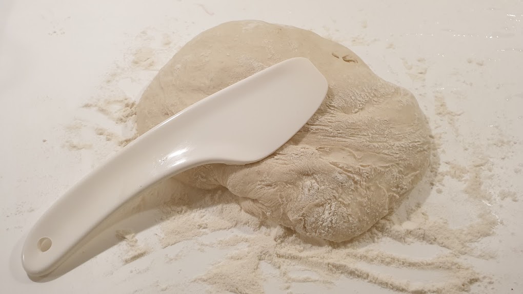 Bild på jäsande bröd och degskrapa